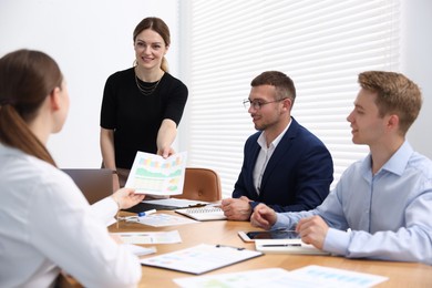 Photo of Business coach giving presentation to group of people in office