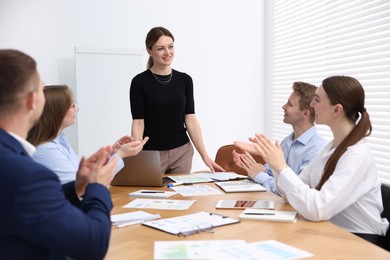 Photo of Business coach giving presentation to group of people in office