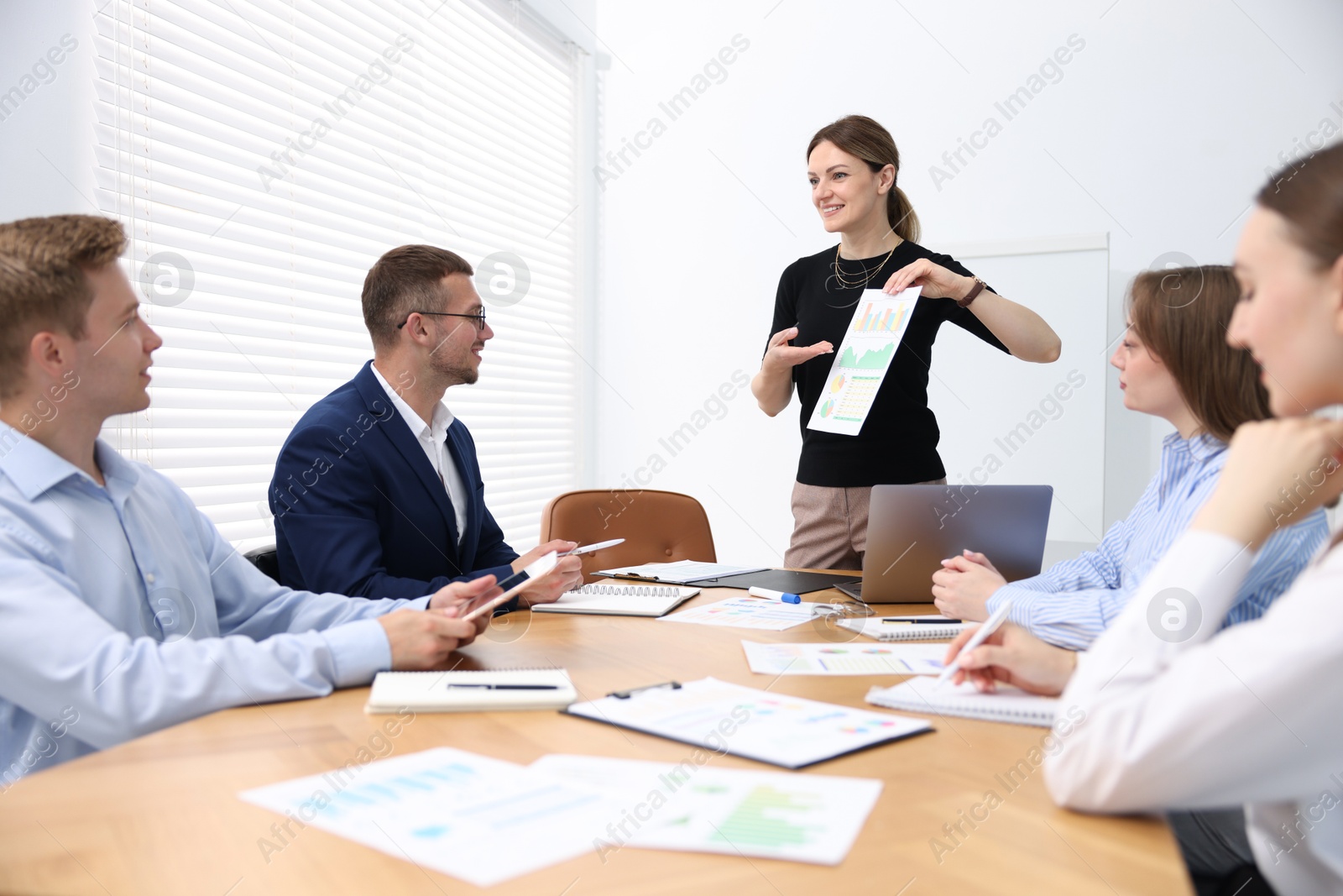Business coach giving presentation to group of people in office Photo of Business coach giving presentation to group of people in office