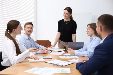 Photo of Business coach giving presentation to group of people in office