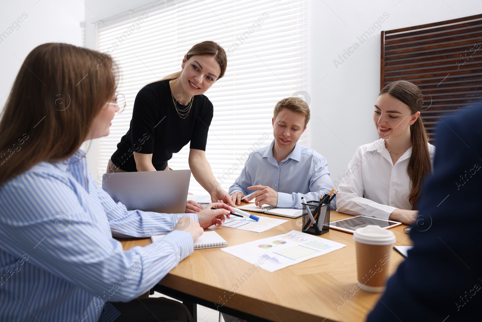 Business coach giving presentation to group of people in office Photo of Business coach giving presentation to group of people in office