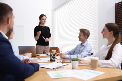Photo of Business coach giving presentation to group of people in office