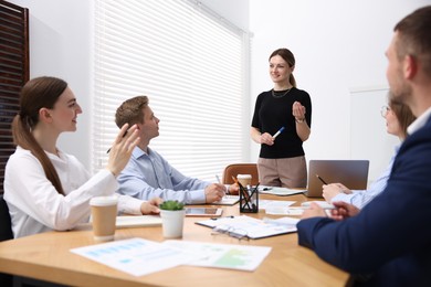 Photo of Business coach giving presentation to group of people in office