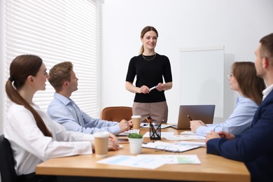 Photo of Business coach giving presentation to group of people in office