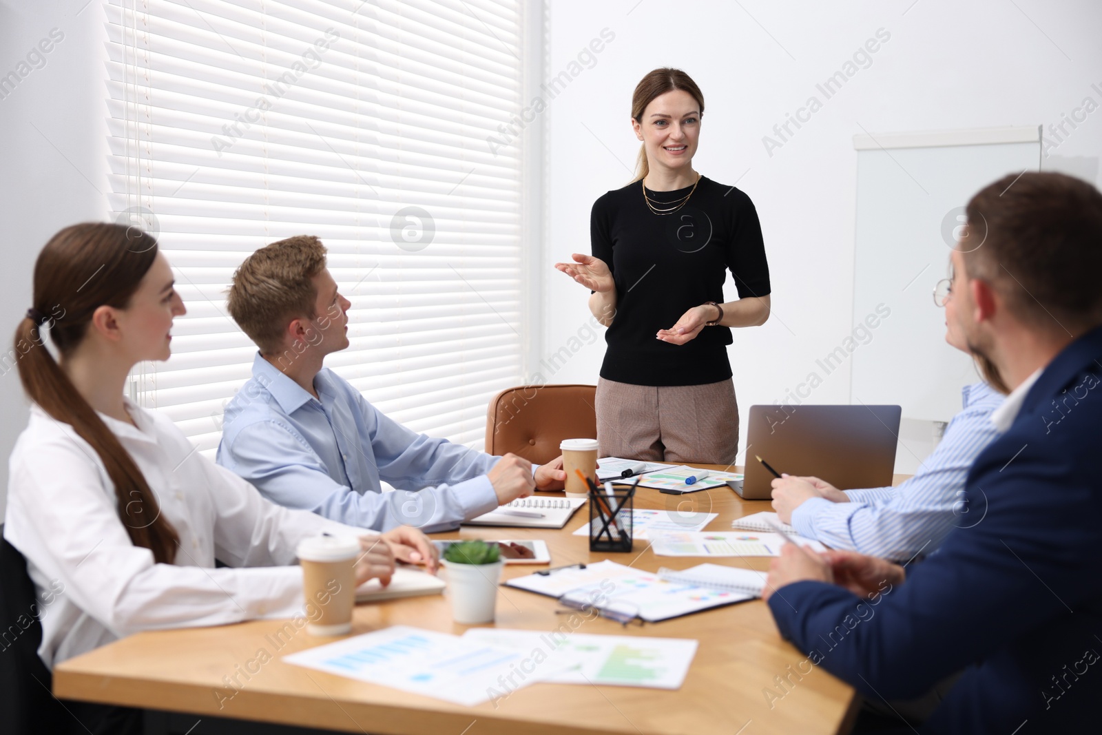 Business coach giving presentation to group of people in office Photo of Business coach giving presentation to group of people in office