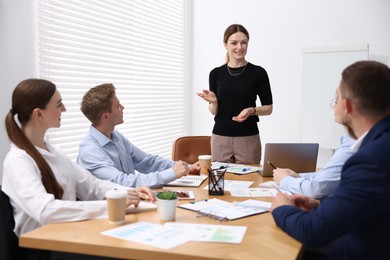 Photo of Business coach giving presentation to group of people in office