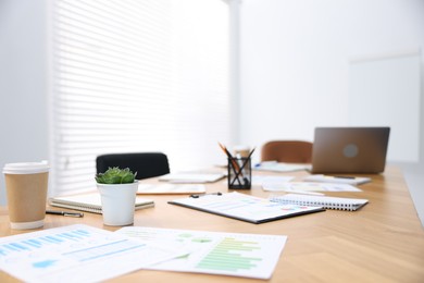 Photo of Stylish workplace with stationery and laptop in office, selective focus