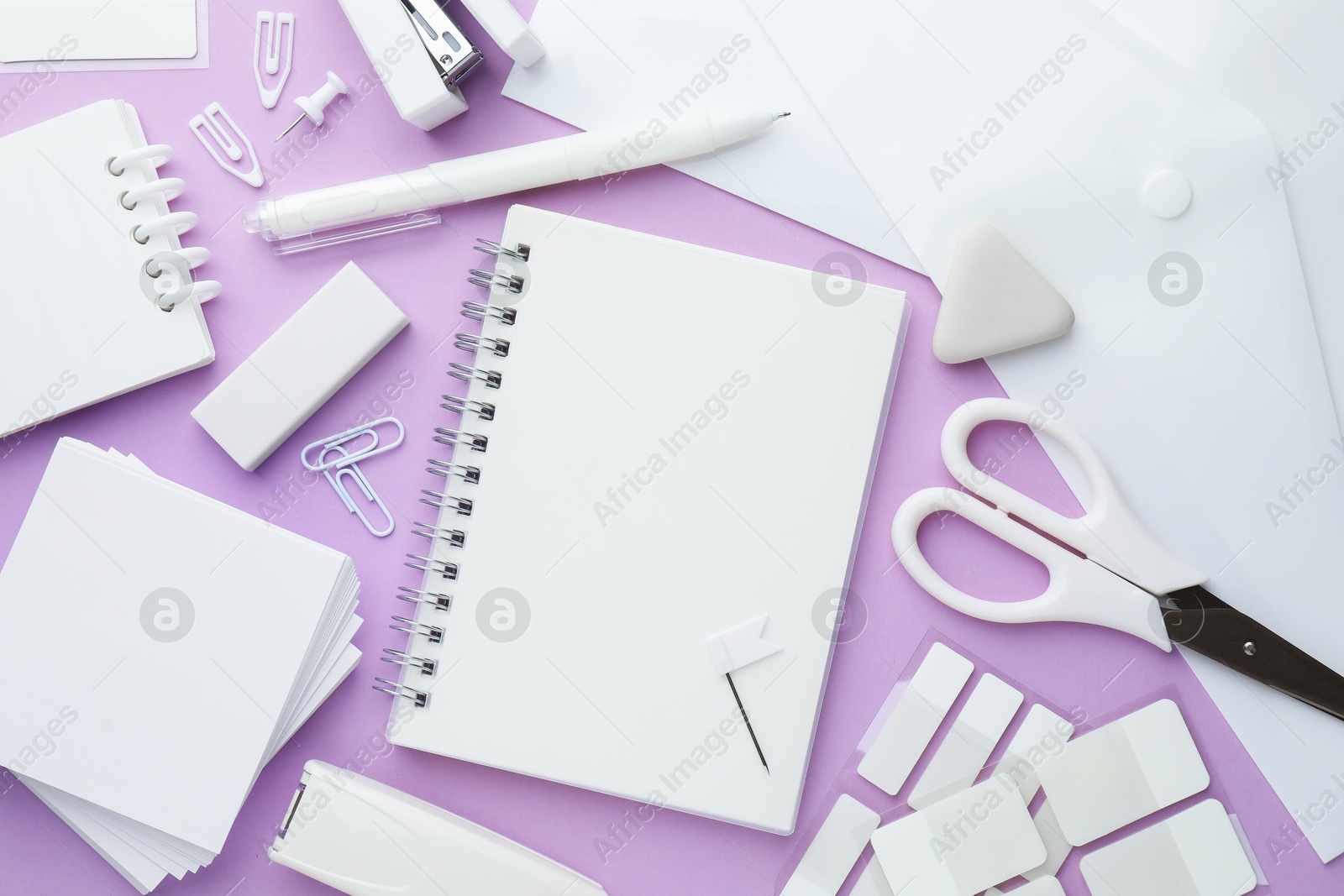 Different white stationery on violet background, flat lay Photo of Different white stationery on violet background, flat lay