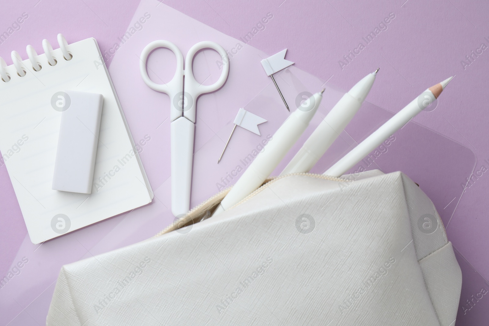 Different white stationery on violet background, flat lay Photo of Different white stationery on violet background, flat lay