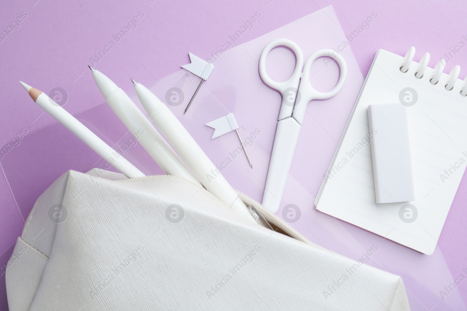 Different white stationery on violet background, flat lay Photo of Different white stationery on violet background, flat lay
