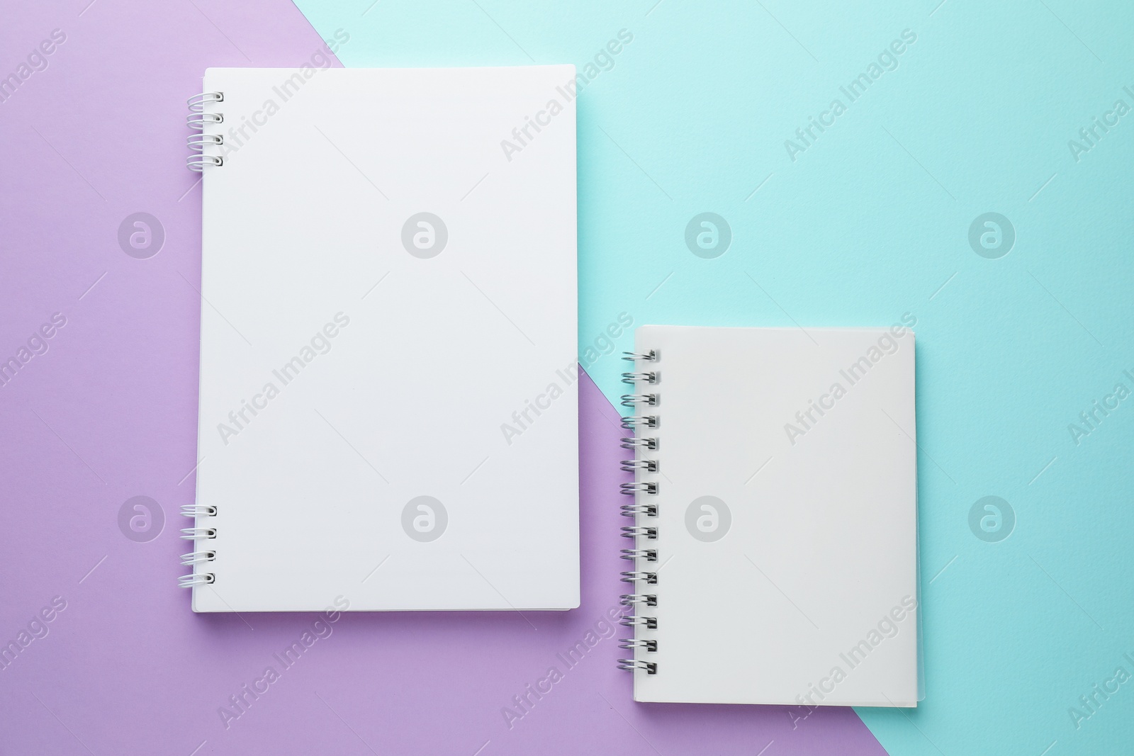 White notebooks on color background, flat lay Photo of White notebooks on color background, flat lay