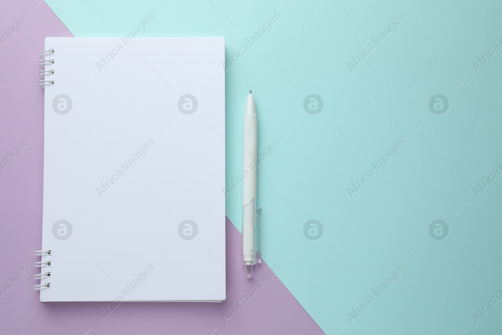 White notebook and pen on color background, flat lay. Space for text Photo of White notebook and pen on color background, flat lay. Space for text