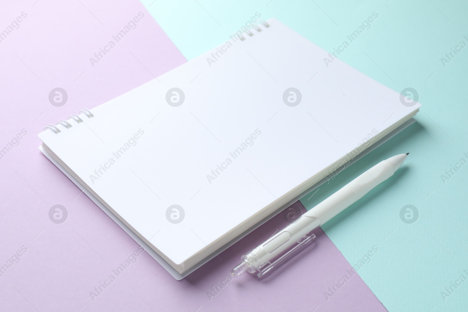 White notebook and pen on color background, closeup Photo of White notebook and pen on color background, closeup
