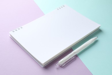 Photo of White notebook and pen on color background, closeup