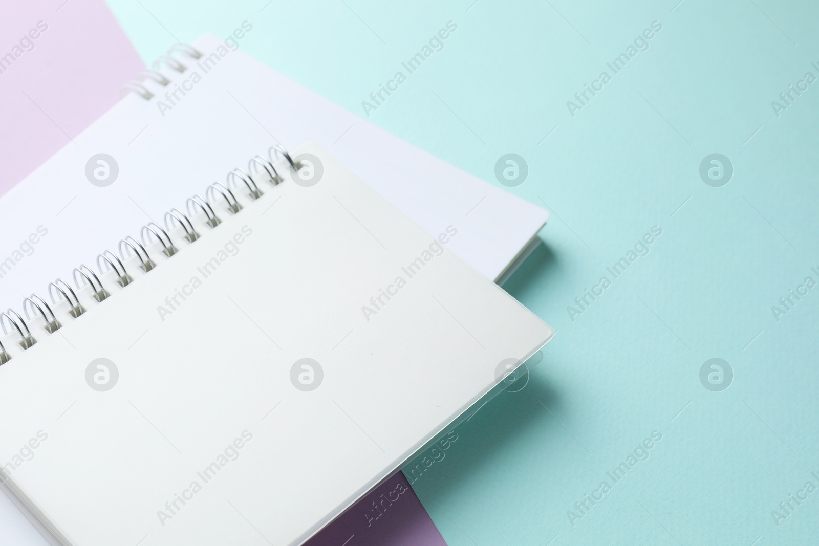 White notebooks on color background, closeup. Space for text Photo of White notebooks on color background, closeup. Space for text