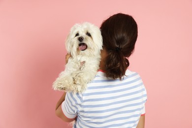 Photo of Happy teenage girl with Maltese dog on pink background, back view