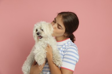 Photo of Happy teenage girl with Maltese dog on pink background