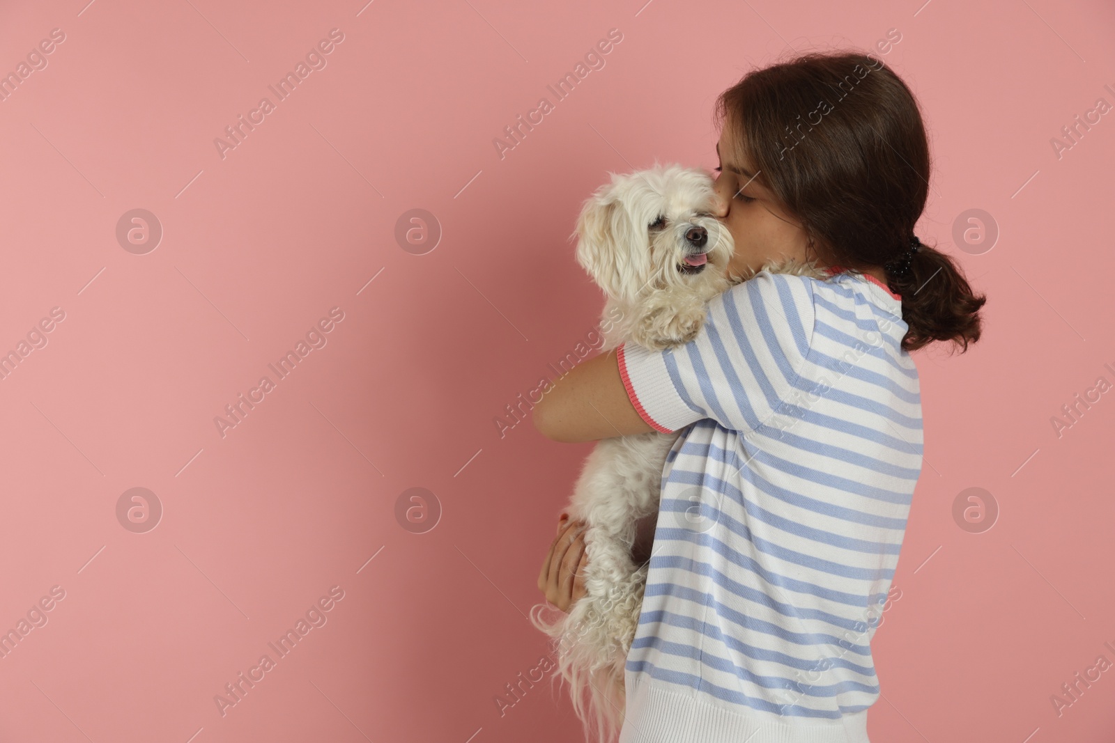 Happy teenage girl with Maltese dog on pink background, space for text Photo of Happy teenage girl with Maltese dog on pink background, space for text