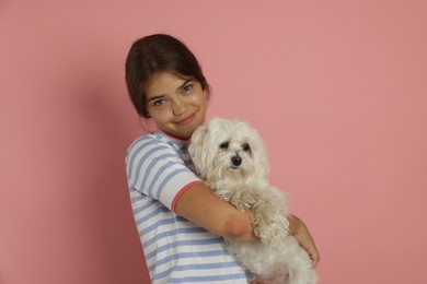 Photo of Happy teenage girl with Maltese dog on pink background