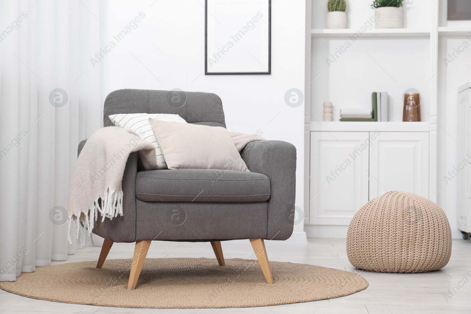 Photo of Comfortable grey armchair in living room. Interior design