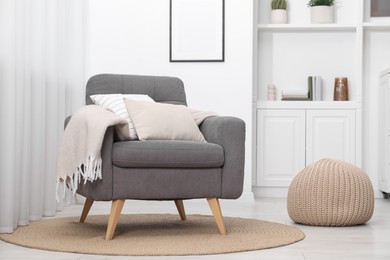 Photo of Comfortable grey armchair in living room. Interior design