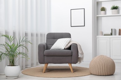 Photo of Comfortable grey armchair in living room. Interior design