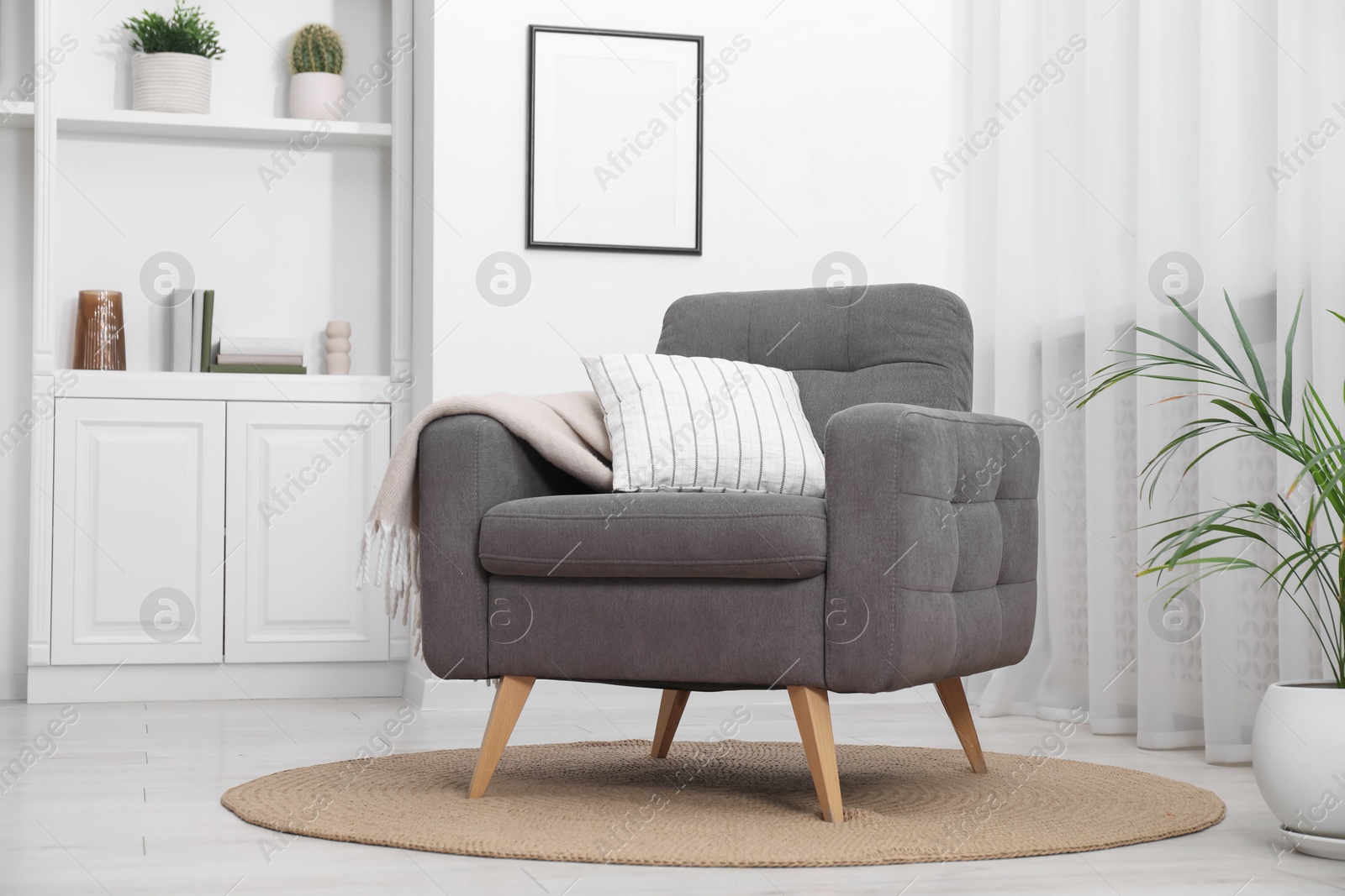 Photo of Comfortable grey armchair in living room. Interior design
