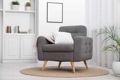 Photo of Comfortable grey armchair in living room. Interior design