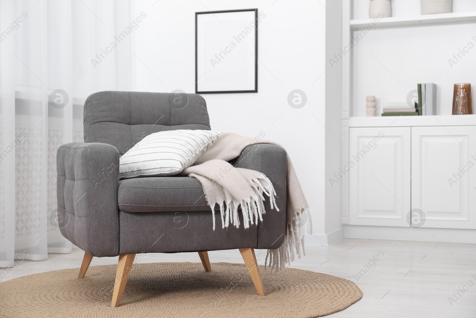 Photo of Comfortable grey armchair in living room. Interior design