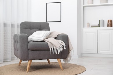 Photo of Comfortable grey armchair in living room. Interior design