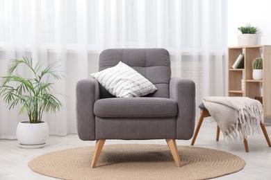 Photo of Comfortable grey armchair in living room. Interior design