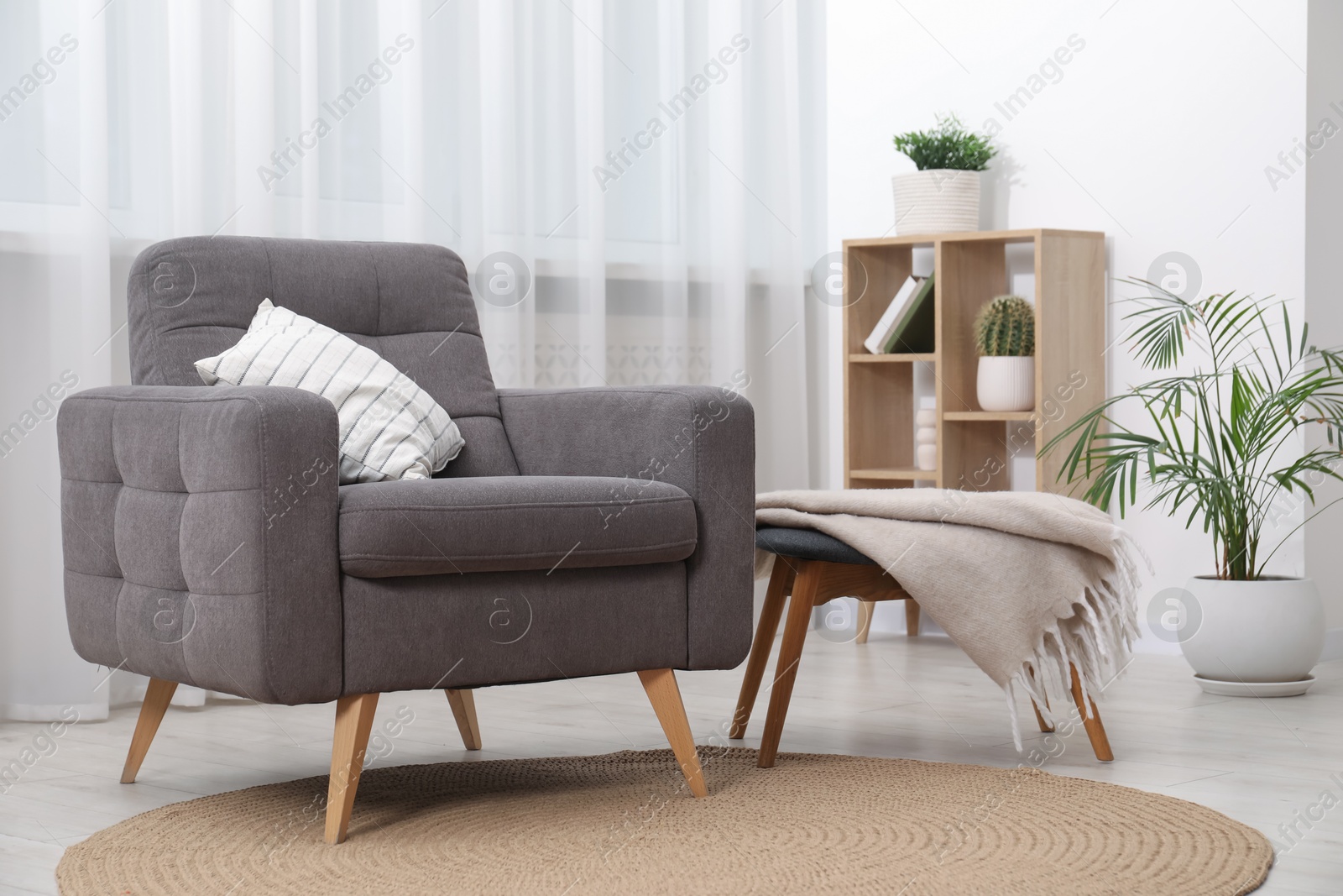 Photo of Comfortable grey armchair in living room. Interior design