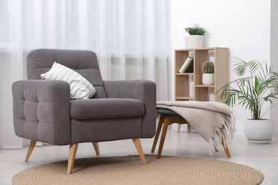 Photo of Comfortable grey armchair in living room. Interior design