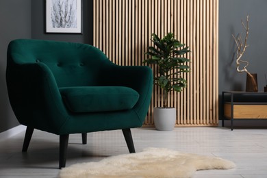Photo of Comfortable dark green armchair in living room. Interior design
