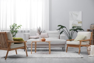Photo of Comfortable armchairs and other furniture in living room. Interior design