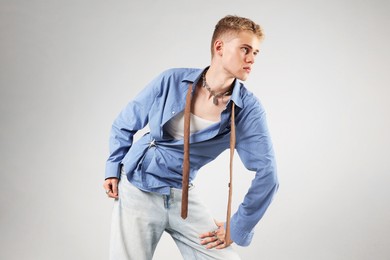 Photo of Handsome young man wearing stylish clothes on light grey background