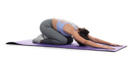 Photo of Teenage girl in sportswear stretching on mat against white background