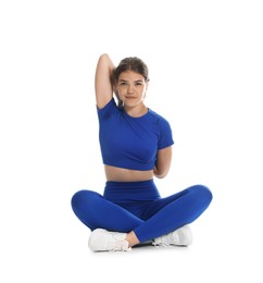 Photo of Teenage girl in sportswear stretching on white background