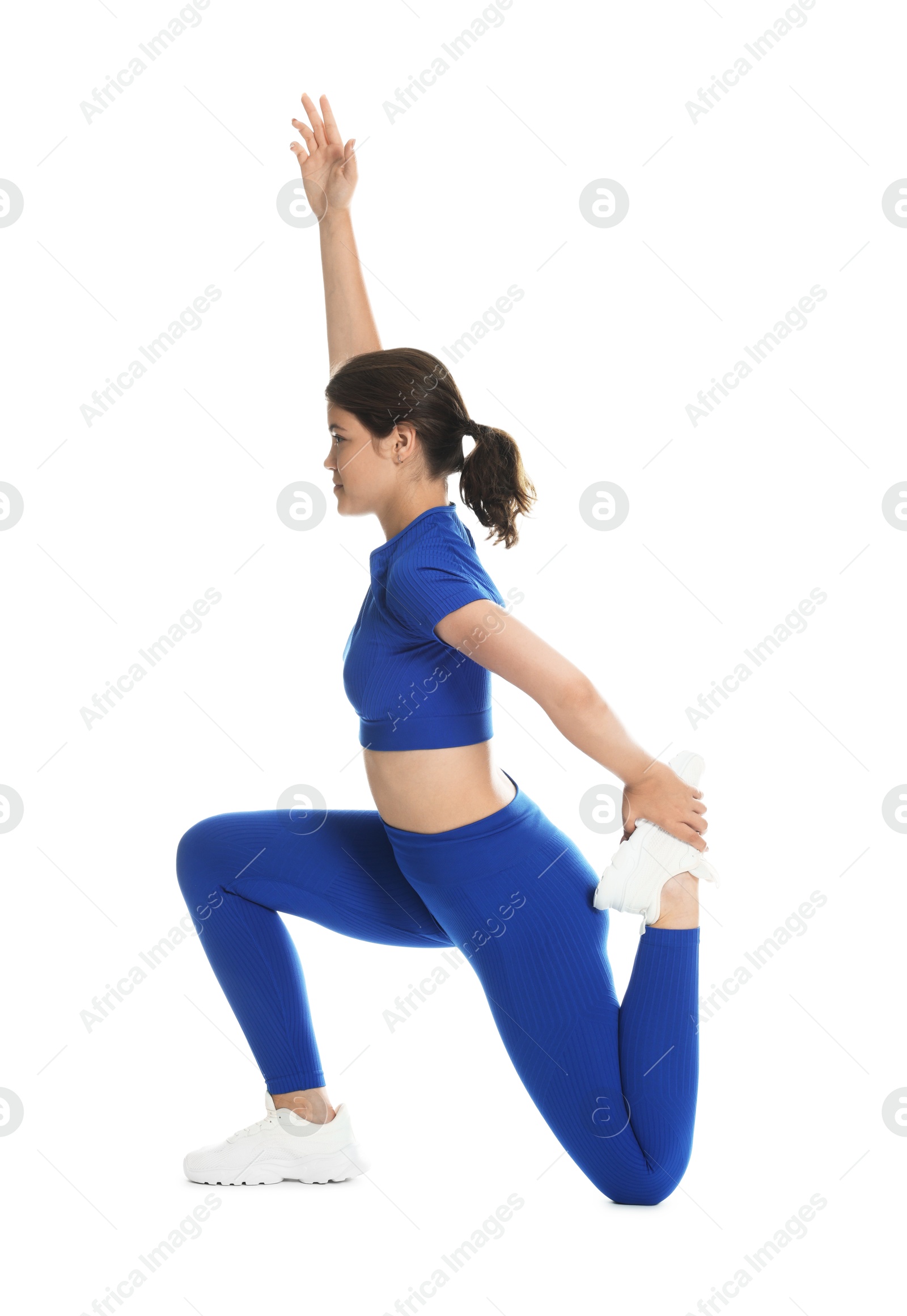 Photo of Teenage girl in sportswear stretching on white background
