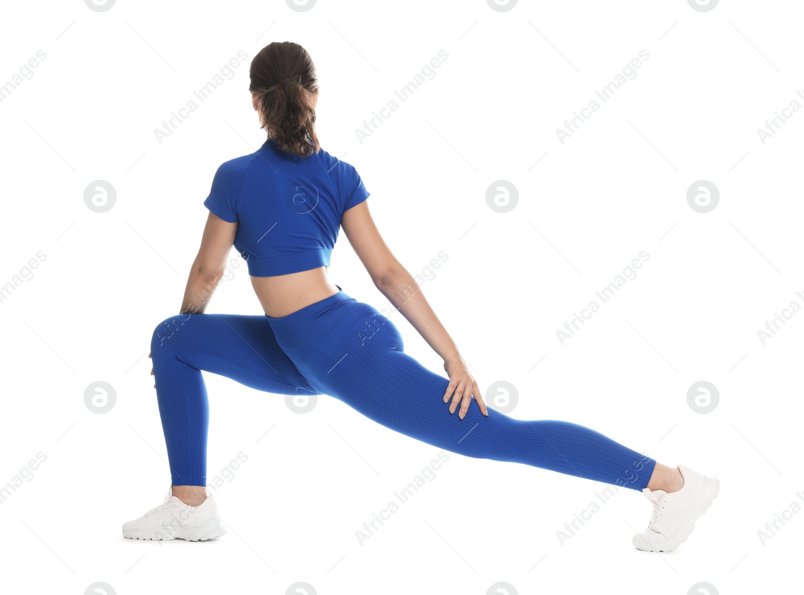 Photo of Teenage girl in sportswear stretching on white background