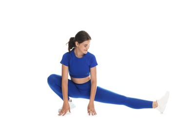 Photo of Teenage girl in sportswear stretching on white background