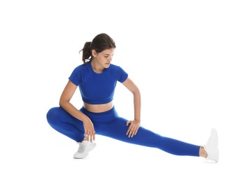 Photo of Teenage girl in sportswear stretching on white background