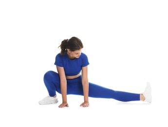 Photo of Teenage girl in sportswear stretching on white background