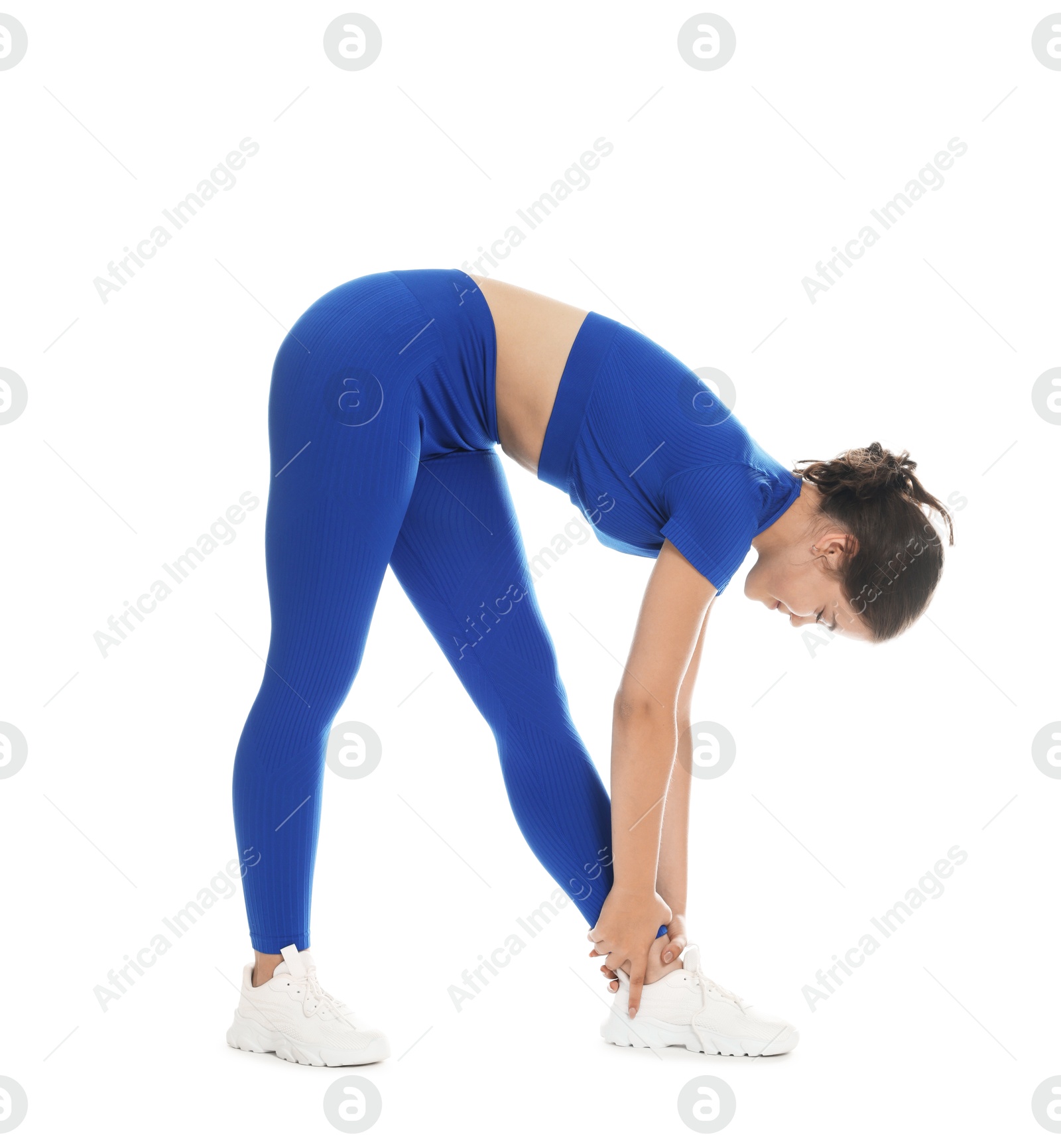 Photo of Teenage girl in sportswear stretching on white background
