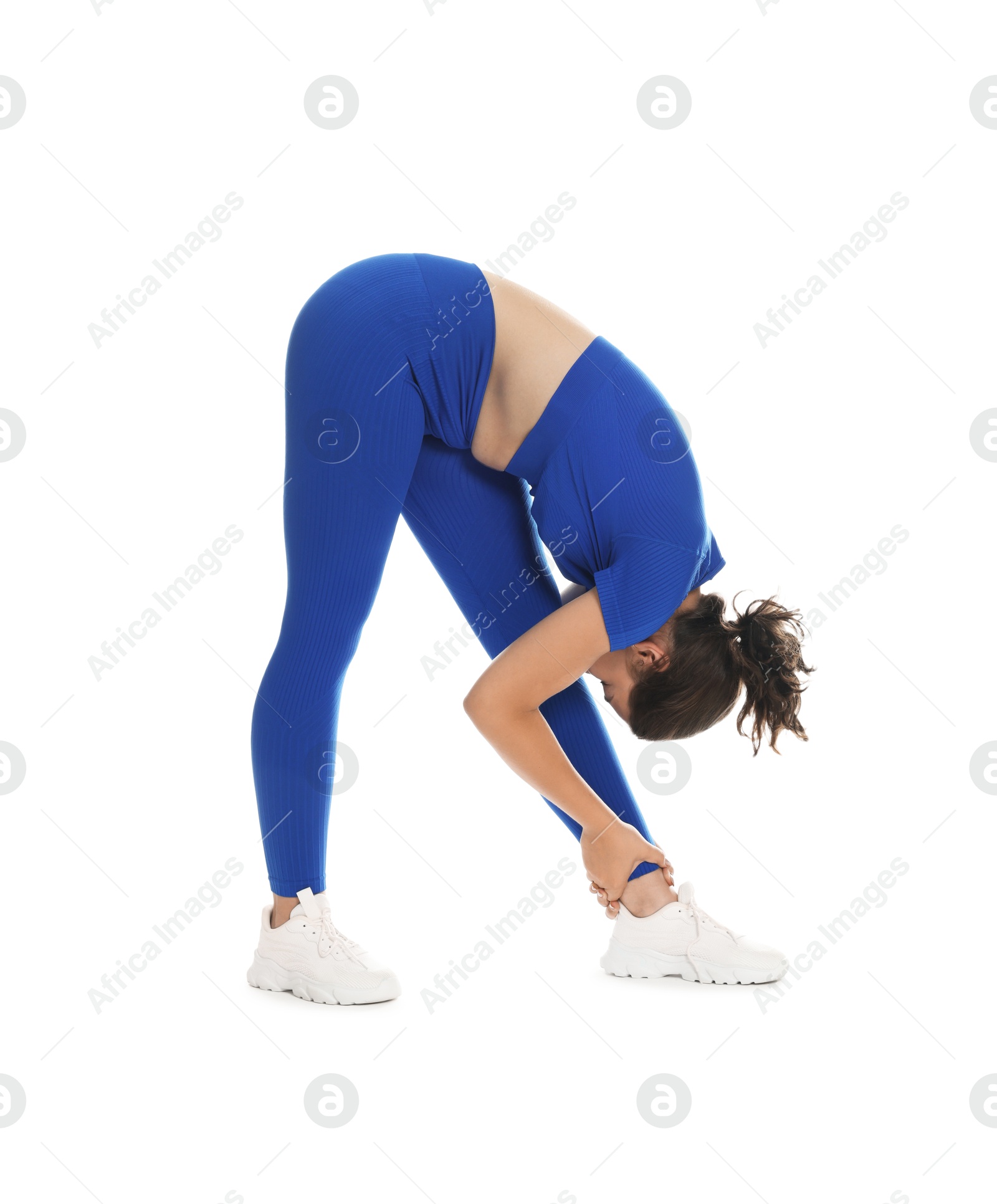 Photo of Teenage girl in sportswear stretching on white background