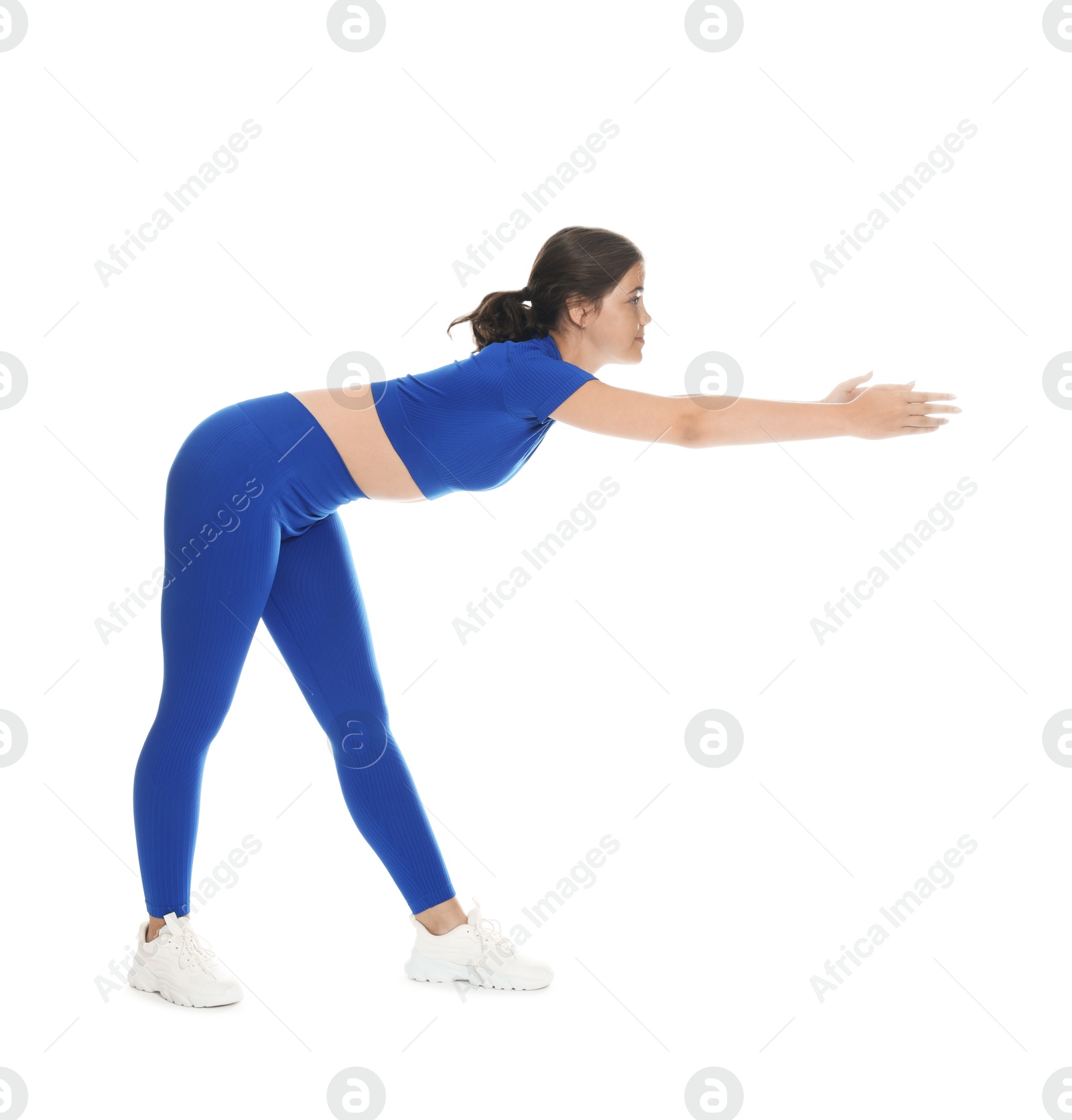 Photo of Teenage girl in sportswear stretching on white background