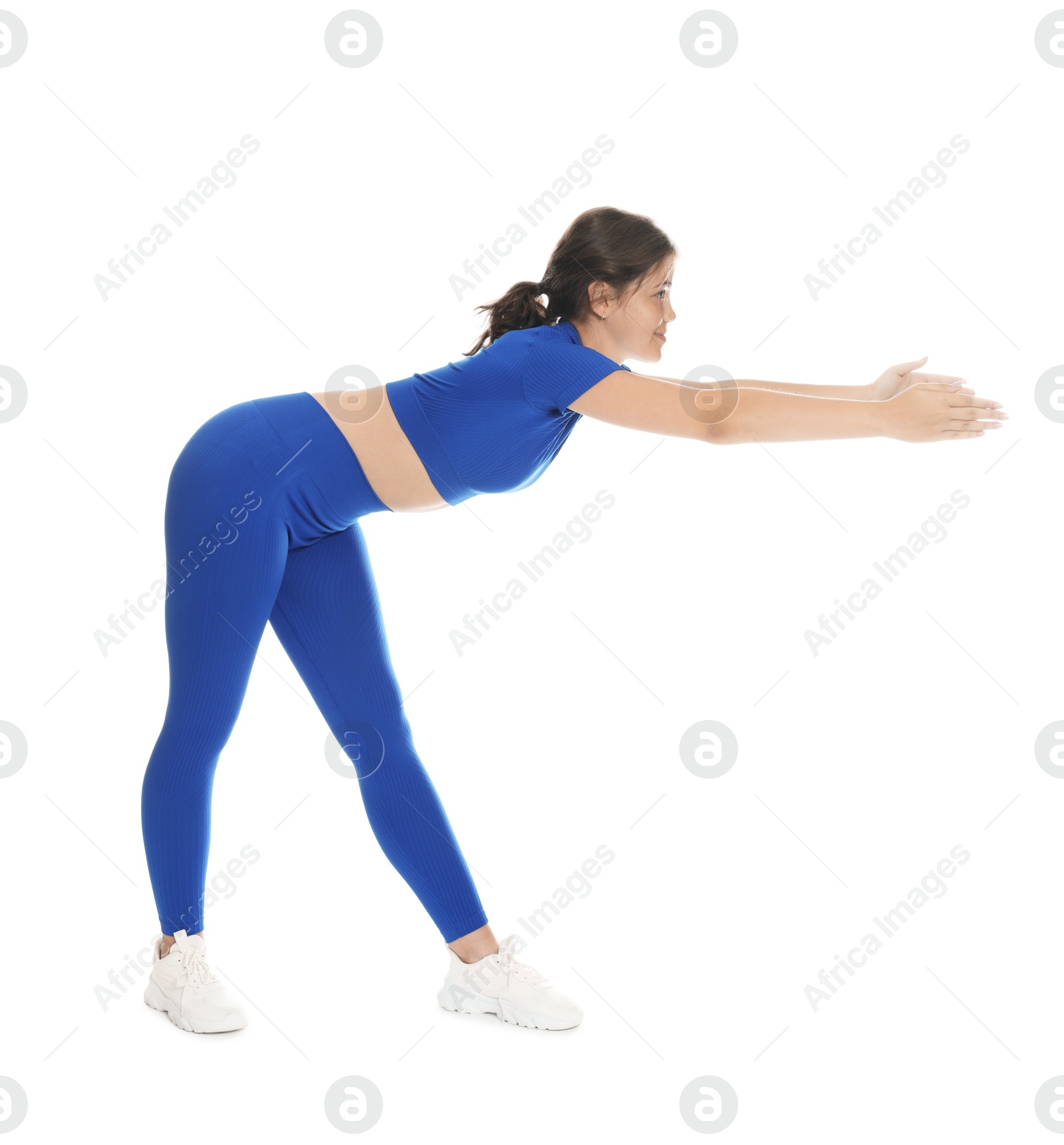 Photo of Teenage girl in sportswear stretching on white background