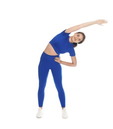 Photo of Teenage girl in sportswear stretching on white background