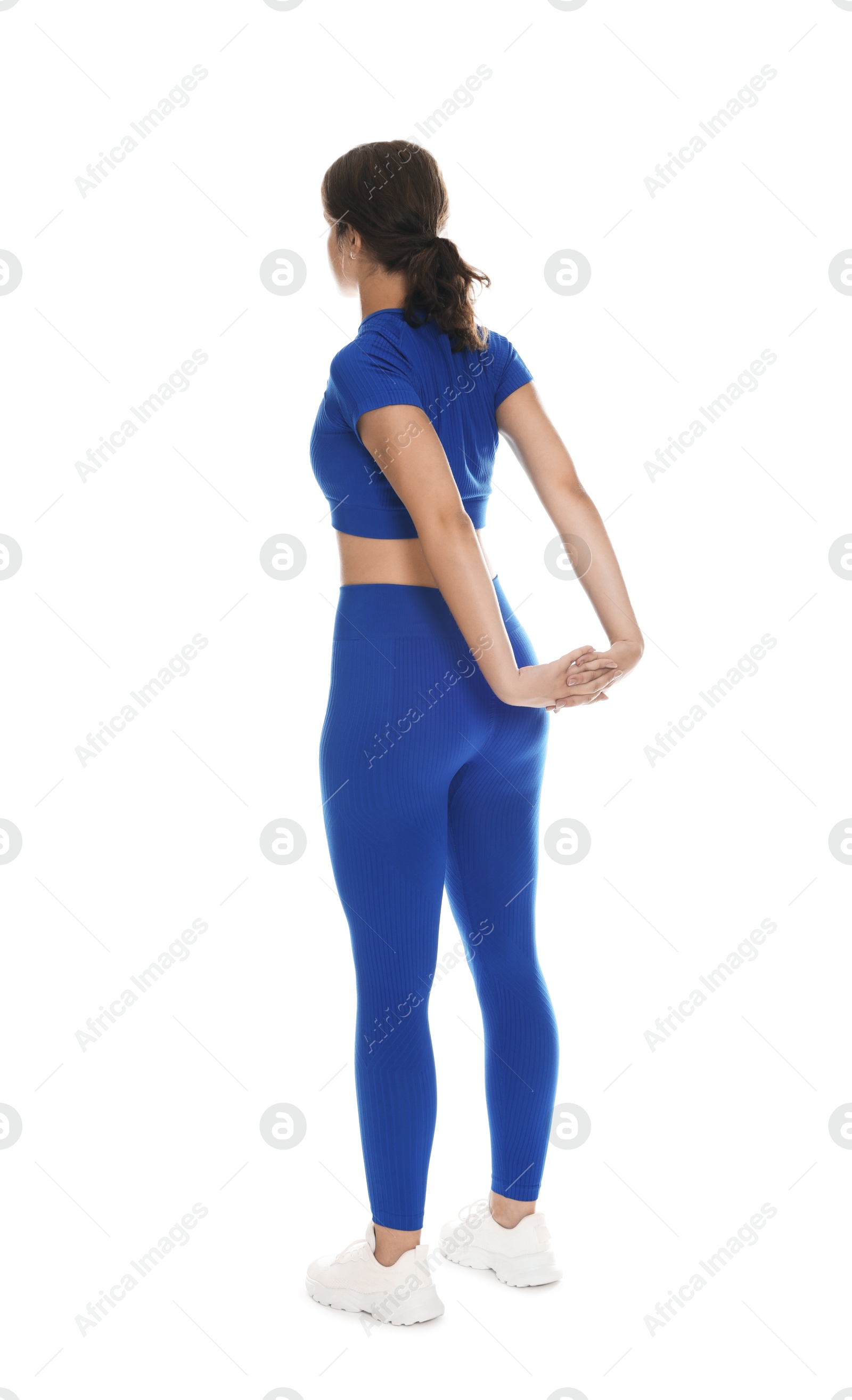 Photo of Teenage girl in sportswear stretching on white background