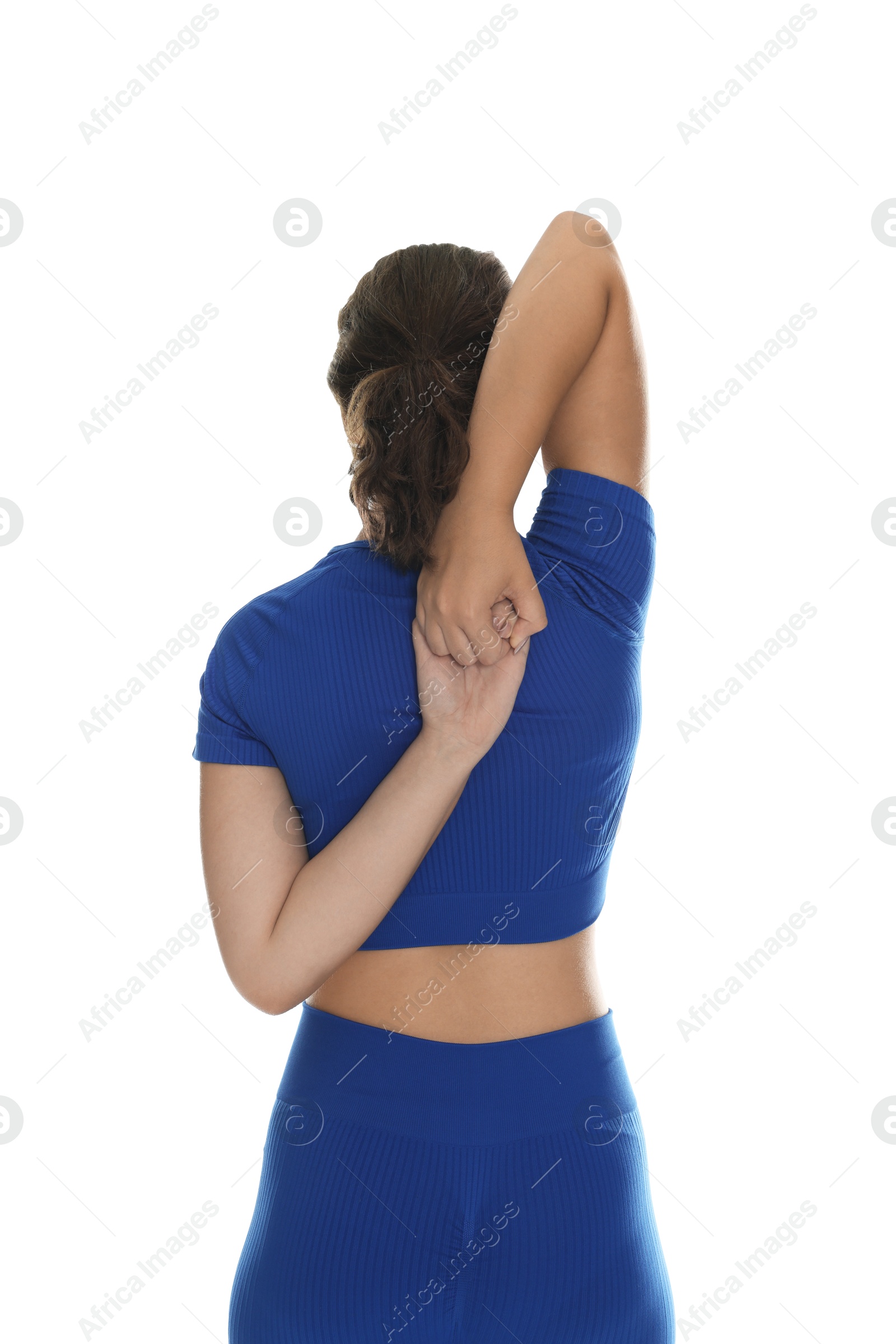 Photo of Teenage girl in sportswear stretching on white background, back view